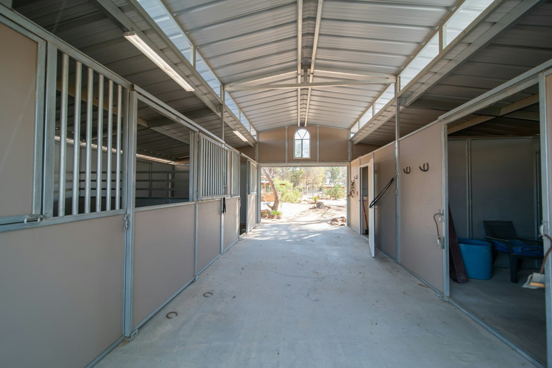 Allée de boxes d'une écurie de pension accueillant les chevaux de propriétaires
